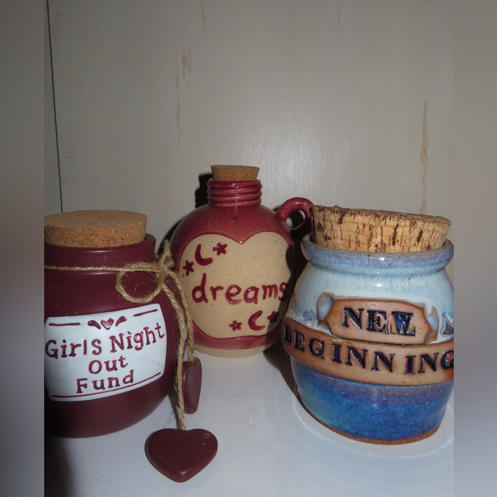 Three medium sized pottery banks. Each topped with a secure cork stopper.